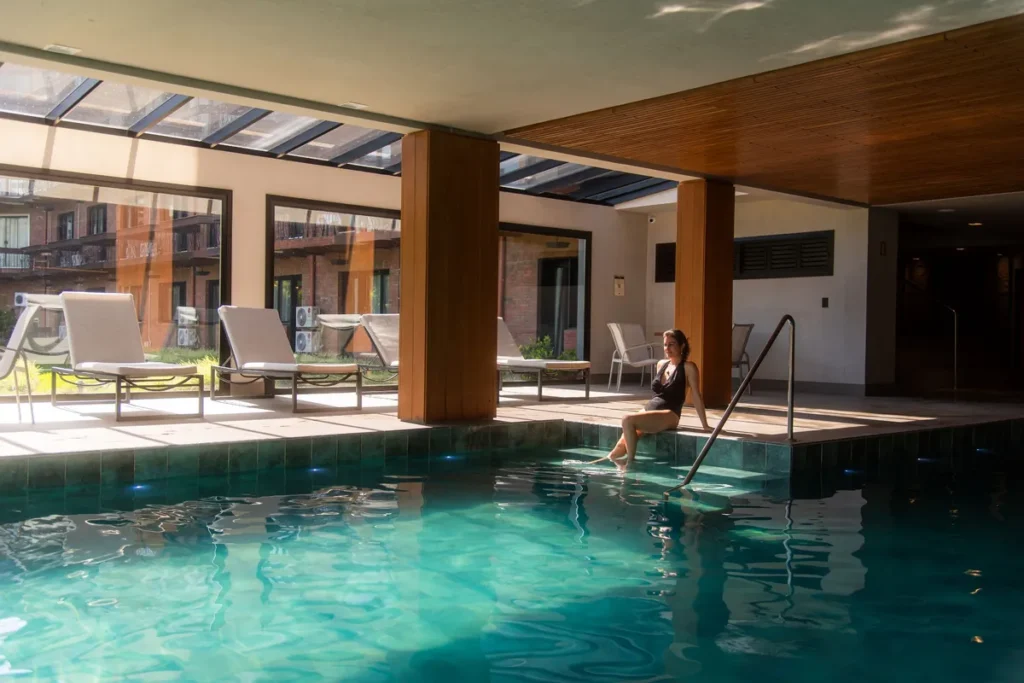 Piscina aquecida interna do spa do Hotel Alpestre Gramado com área de descanso.