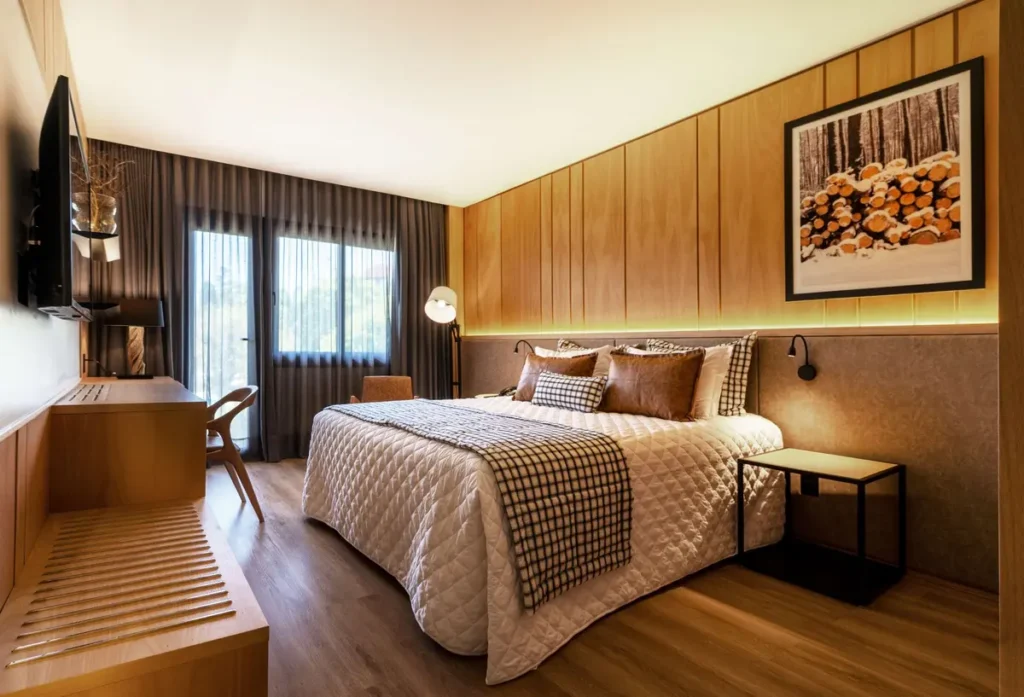Quarto com varanda e vista para o jardim no Hotel Alpestre Gramado.