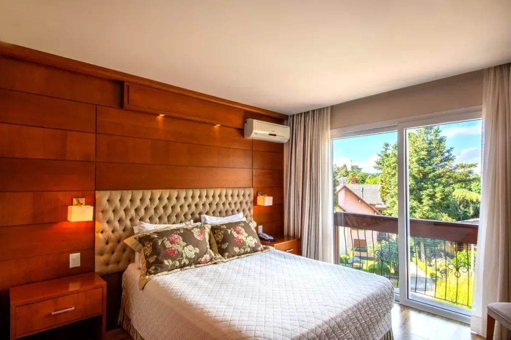 Quarto Super Luxo Vista Cidade com varanda e iluminação natural no Hotel Alpestre Gramado.
