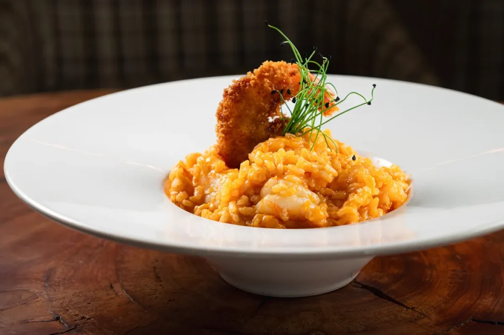 Risoto cremoso de camarão empanado servido no restaurante Le Pin do Hotel Alpestre Gramado.