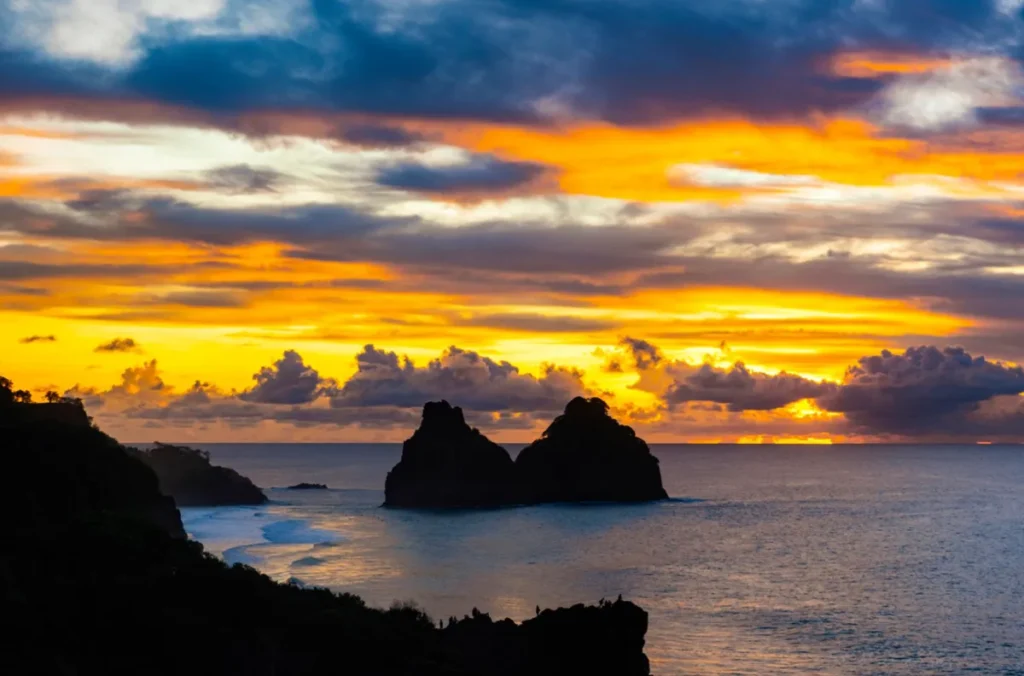 Céu colorido no pôr do sol com Morro Dois Irmãos em Fernando de Noronha.