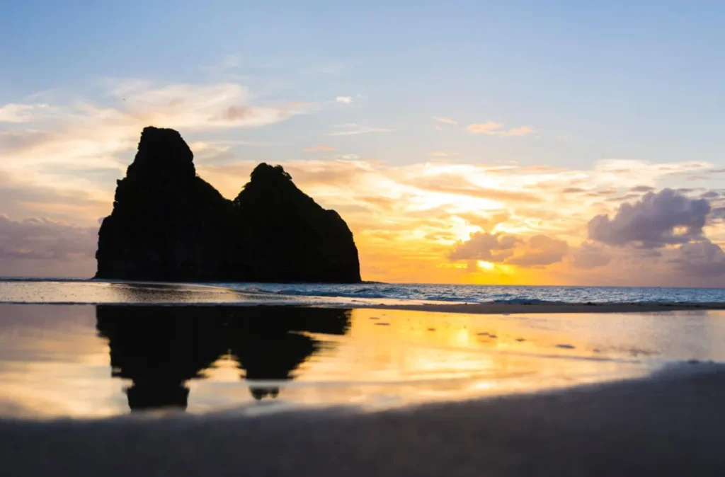 Pôr do sol com silhueta do Morro Dois Irmãos em Fernando de Noronha.