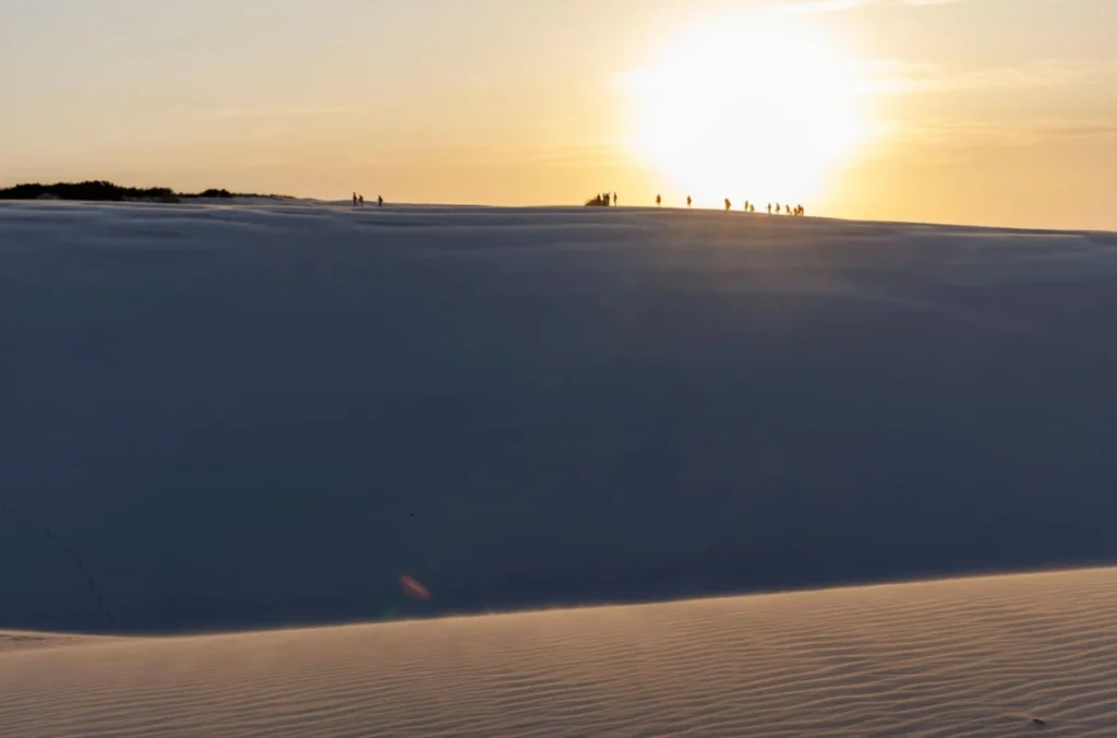 Pôr do sol sobre as lagoas e dunas dos Lençóis Maranhenses visto do alto.