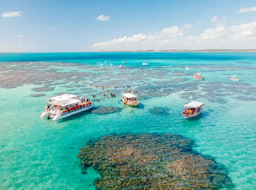 Pacote Maragogi - Barcos e turistas nas piscinas naturais de águas azul-turquesa em Maragogi