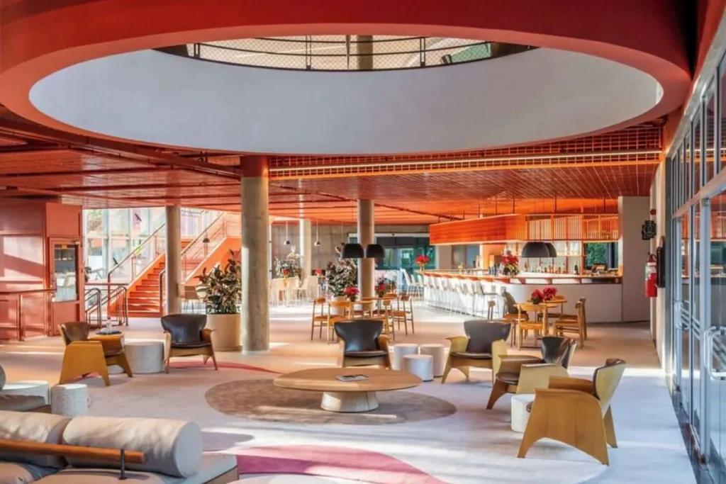Lobby do Almenat Embu das Artes com lounge, bar e espaços de convivência em ambiente contemporâneo.