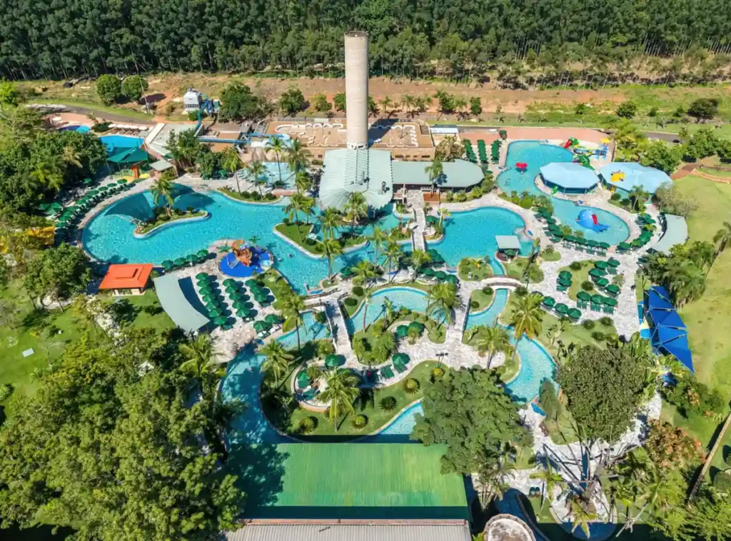 Vista aérea do complexo de piscinas do Blue Tree Thermas de Lins, cercado por jardins e áreas verdes.
