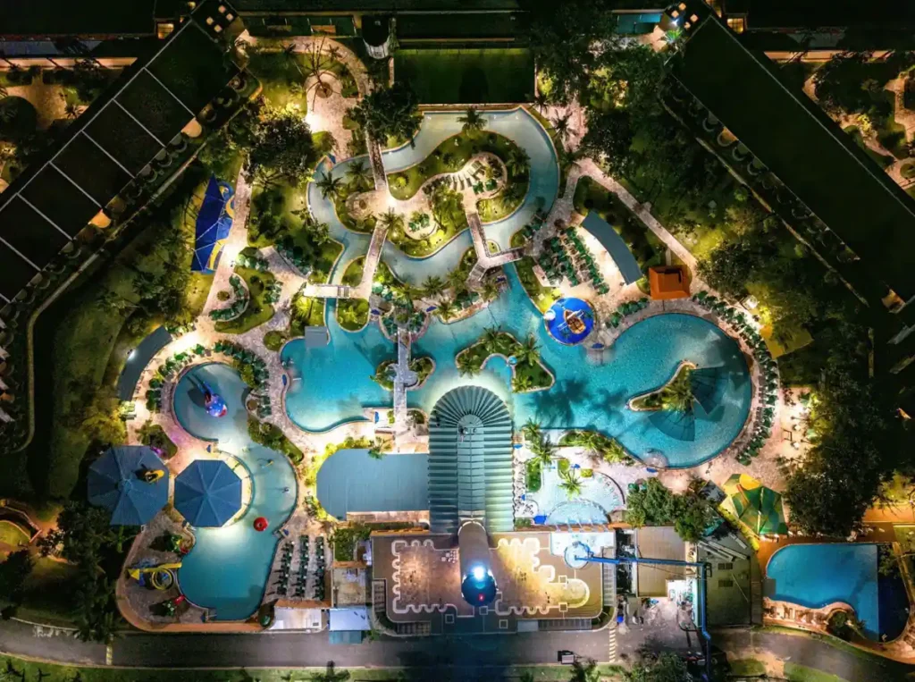 Vista aérea noturna do complexo de piscinas iluminadas do Blue Tree Thermas de Lins.