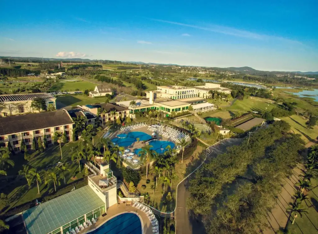 Vista aérea do Club Med Lake Paradise, com piscinas, áreas verdes e o lago ao redor do resort.