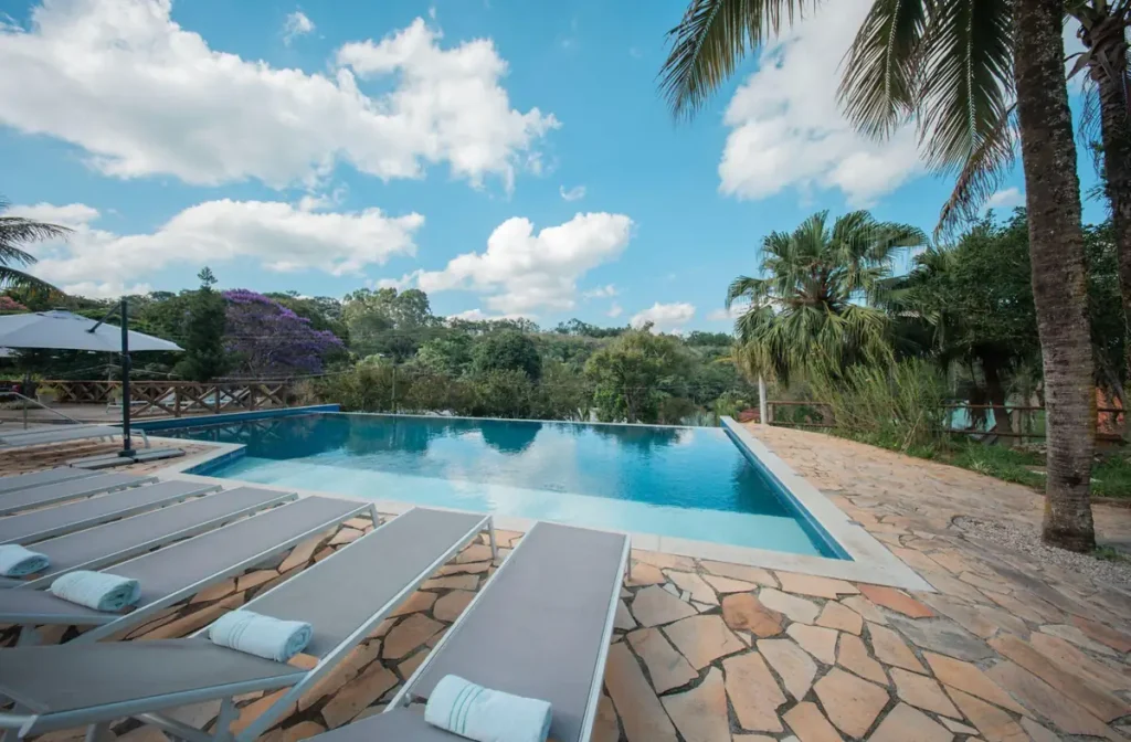 Piscina externa do Matiz Igaratá Resort com borda infinita, espreguiçadeiras e vista para a natureza.