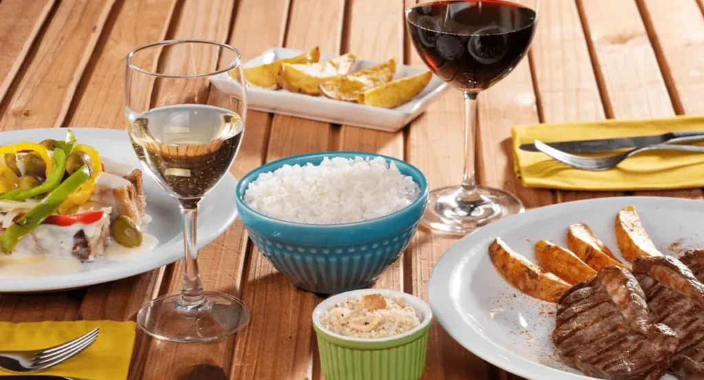 Refeição do Restaurante Galés no Salinas Maragogi, com carnes, arroz, acompanhamentos e bebidas.