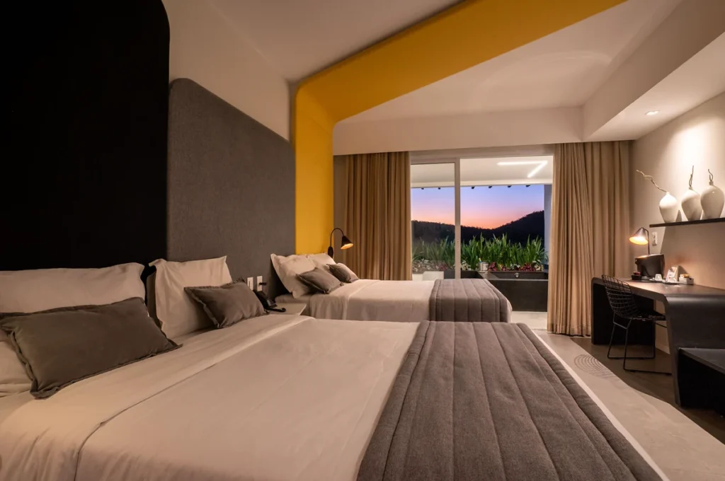 Quarto moderno e espaçoso do Tauá Resort Atibaia, com varanda e vista para a área externa.