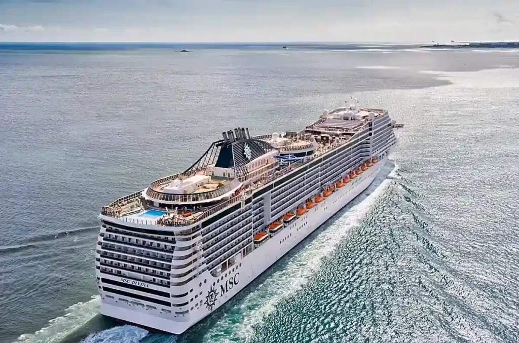 MSC Divina em navegação, com destaque para a área de lazer na popa, piscinas e cabines com varanda.